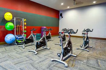 A gym with exercise equipment and a patterned carpet